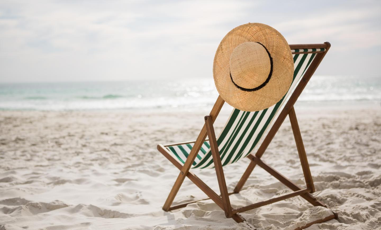 straw-hat-kept-empty-beach-chair.jpg